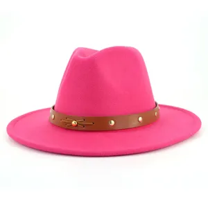 Rosa Wollfilz Fedora Hut Detail, mit einem braunen Lederband und goldenen Nieten verziert.