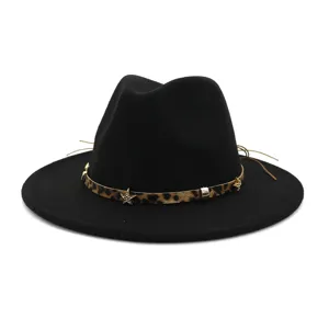 Gros plan sur les détails du chapeau fedora noir avec bande léopard et étoiles en métal dorées.