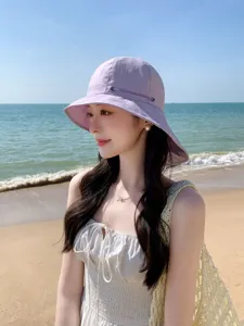 Vue detaillee du chapeau de soleil violet clair, large bord pour les vacances a la plage.