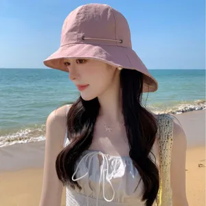 Le chapeau de soleil rose élégant à large bord offre une protection anti UV idéale en plage.