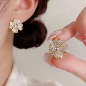 Exquisitos pendientes de tuerca de trébol chapados en oro con circonitas, joyas elegantes.