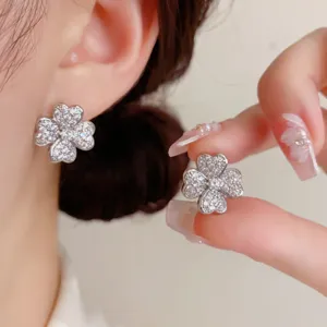 Exquisitos pendientes de trébol de circonita brillante, detalle de joyería de lujo.