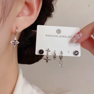 Primer plano detallado de pendientes de cruz retro y set de tachuelas, joyería de moda top.