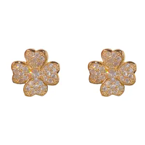 Exquisitos pendientes de trébol con circonitas brillantes, elegante diseño en tono dorado.