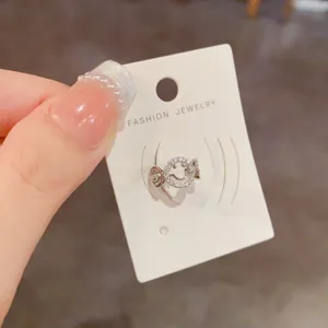 Silberne Strass-Smiley Ohrklemme, minimalistischer Modeschmuck ohne Ohrring Detail.