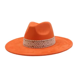 Detailopname van de helderoranje suède fedora hoed met een stijlvolle geweven band.