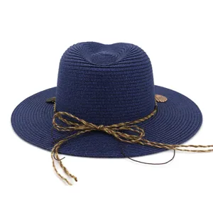 Nahaufnahme des eleganten dunkelblauen Strohhutes mit geflochtener Seidenschleife und Anhängern.