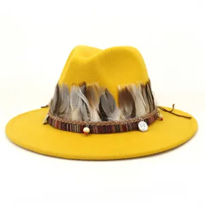 Sombrero de fieltro amarillo estilo jazz con banda de plumas y colgantes de monedas.