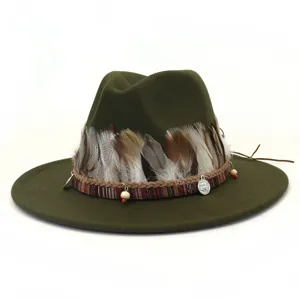 Detalle de fedora de lana verde militar, banda de plumas étnica con abalorios y dijes.