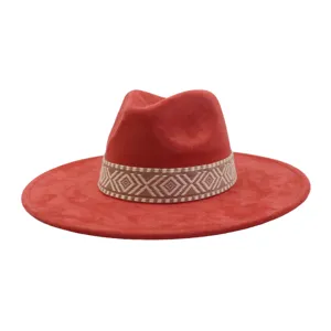 Close-up detailopname van rode faux suède fedora hoed met etnisch patroon geweven band.