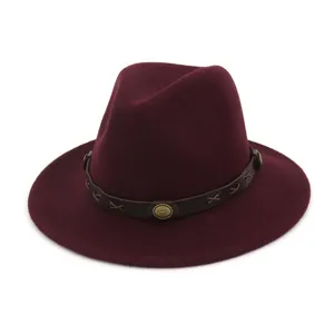Primer plano del sombrero fedora rojo vino, con cinturón de cuero marrón y botones metálicos.