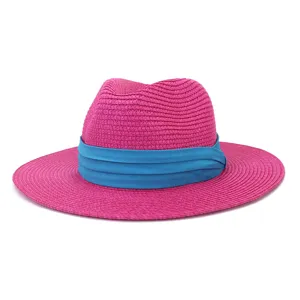 Vue detaillee du chapeau de paille rose avec ruban bleu, parfait pour le style de plage.