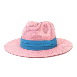 Vue détaillée du chapeau de paille rose avec élégant ruban bleu pour la plage d'été.
