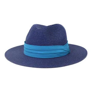 Gros plan sur les details du chapeau de paille bleu, texture tressee fine et ruban vif.