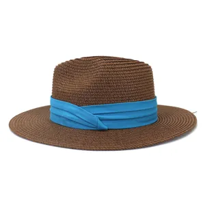 Vue détaillée du chapeau fedora en paille marron avec un élégant ruban plissé bleu.