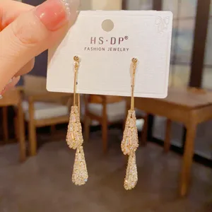 Gros plan de boucles d'oreilles pendantes en zircone étincelante, design élégant et brillant.
