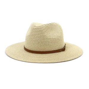 Detail van een stijlvolle beige geweven strooien hoed met bruine lederen riem en metalen gesp.