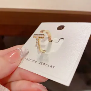 Elegant T-shaped open ring with delicate pearls, stylish gold-plated fashion jewelry design.