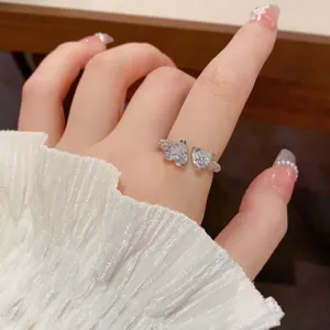 Detailed close-up of a sparkling double heart zircon open ring with elegant silver band design.