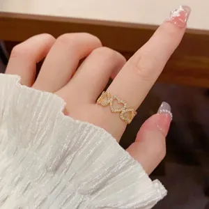 Gold-plated open ring featuring interlocking heart shapes and sparkling cubic zirconia for women.
