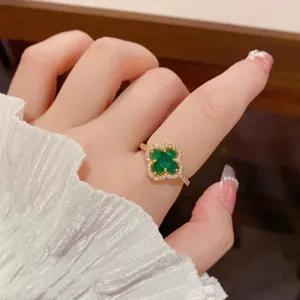 Close-up detail of the green four-leaf clover zircon ring, featuring sparkling paved crystals.