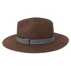 Gros plan bien détaillé du chapeau de paille marron classique avec une bande rayée.