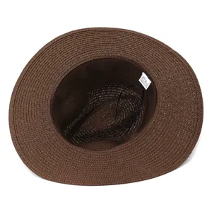 Vue detaillee d'un chapeau de paille marron classique, montrant la texture et l'etiquette interieure.
