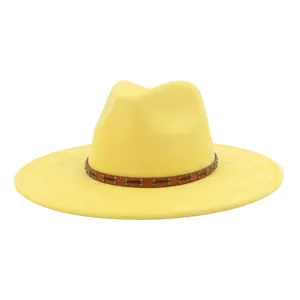 Vista del sombrero fedora amarillo de ante de ala ancha con elegante banda de cuero tachuelada.