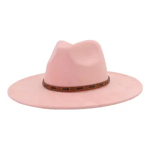 Detalle de sombrero fedora rosa de ala ancha, textura de ante con banda de cuero con tachuelas.