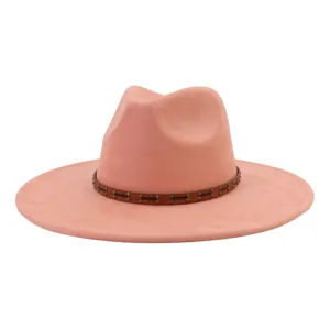 Primer plano del sombrero fedora rosa con banda de tachuelas marrones y textura de ante suave.
