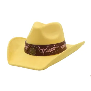 Detailed view of yellow suede cowboy hat with brown studded band, pink embroidery and bull badge.