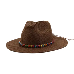 Gros plan sur le chapeau de paille marron avec une bande de perles multicolores et cordon.