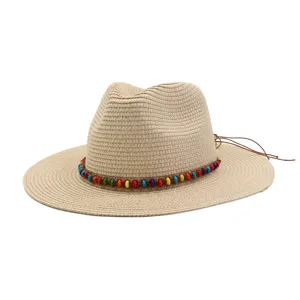 Chapeau de paille Fedora tissé avec bande de perles colorées et lanière en cuir élégante.