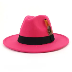 Close up detail view of pink wool felt fedora hat with black band and feather decor.