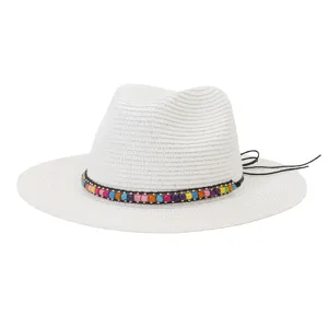 Vue détaillée du chapeau fedora en paille blanche avec bande de perles colorées et cordon.
