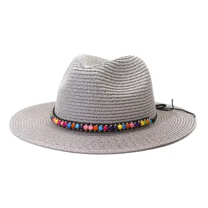 Vue détaillée du chapeau de paille gris d'été avec bande de perles en bois colorées et large bord.
