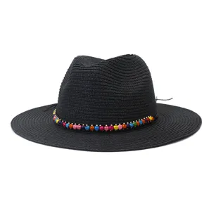 Vue détaillée du chapeau de paille noir avec un bandeau en perles de bois multicolores.