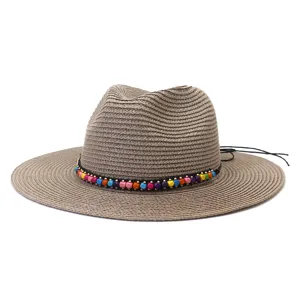 Vue détaillée du chapeau fedora en paille d'été avec perles en bois et large bord.