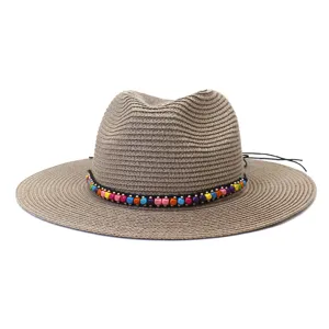 Vue détail du chapeau de paille d'été avec bande de perles colorées pour protection solaire.