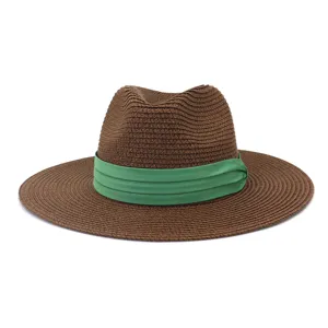 Vue détaillée du chapeau de paille marron avec un élégant ruban vert décoratif.