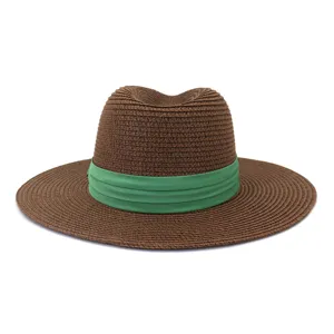 Gros plan détaillé du chapeau de paille marron élégant avec un ruban vert vibrant.