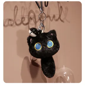 Gros plan détaillé du joli porte-clés en peluche chat noir avec de charmants yeux brodés.