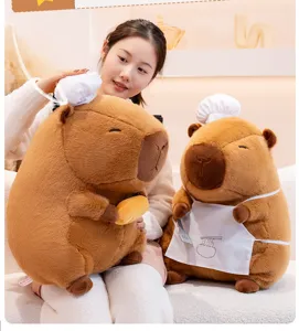 Giant capybara plush toy detail view showing cute chef hat and apron in cozy room setup.