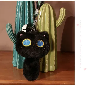 Détail de porte-clés en peluche chat noir mignon avec tissu doux et beaux yeux bleus.