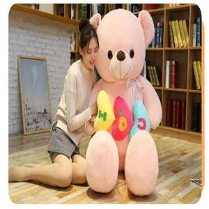 Grande orsacchiotto di peluche rosa con cuscini a cuore colorati regalo romantico.