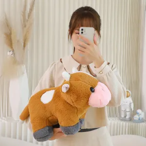 Primo piano dettagliato di un morbido giocattolo di peluche di mucca marrone con muso rosa.