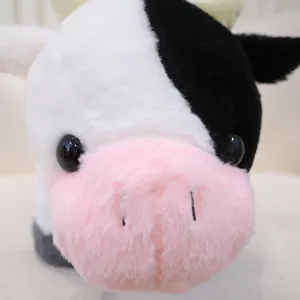 Primo piano dettagliato del simpatico peluche mucca nero e bianco con morbida texture.