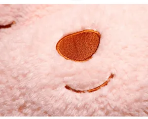 Detailed close-up of a cute pink plush toy face with soft fur and brown embroidered nose.
