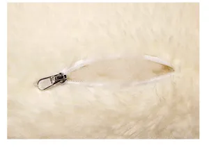 Plush fabric detail shot showing white zipper design for fluffy toy doll or pillow.