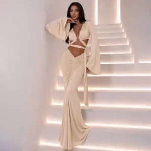 Chic two-piece outfit with long bell sleeves, cutout design, and ruched maxi skirt details.